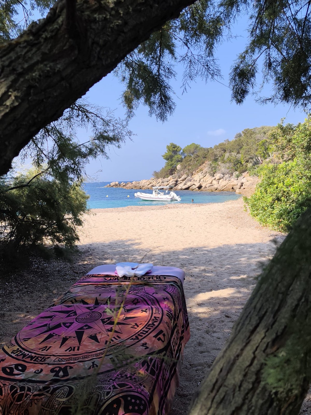 Table de massage prête, crique et eau turquoise en arrière-plan